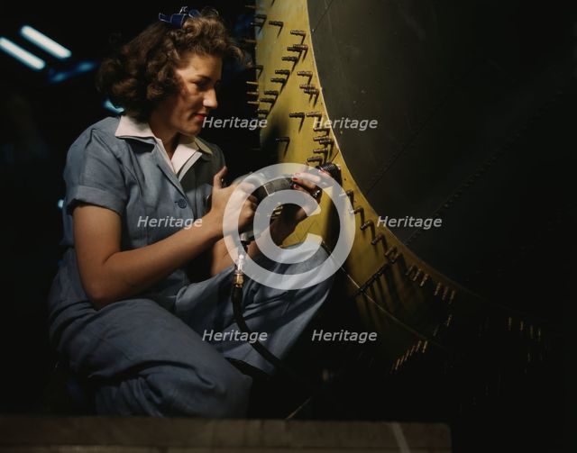 Riveter at work on Consolidated bomber, Consolidated Aircraft Corp., Fort Worth, Texas, 1942. Creator: Howard Hollem.