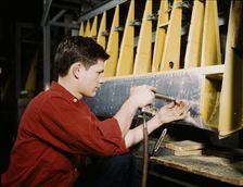 Riveter at work at the Douglas Aircraft Corporation plant in Long Beach, Calif., 1942. Creator: Alfred T Palmer