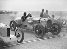 Riley, Buick and Bugatti on the start line at a Surbiton Motor Club race meeting, Brooklands, 1928. Artist: Bill Brunell
