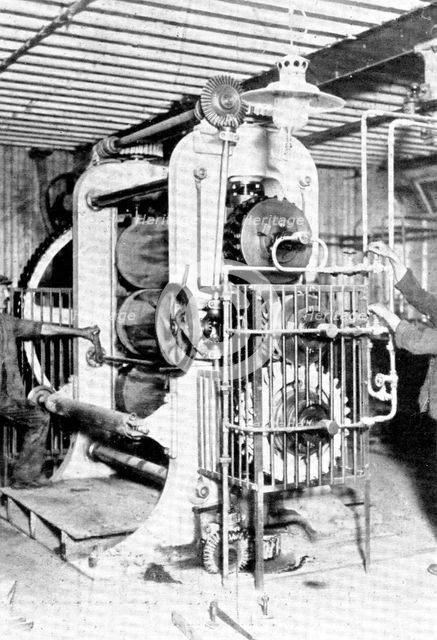 Rubber heels in the making: an elaborate calendering machine which flattens the raw rubber..., 1909. Creator: Unknown.