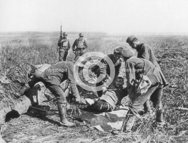 Wounded German soldier being moved by prisoners, Aisne, France, 18 July, 1918. Artist: Unknown