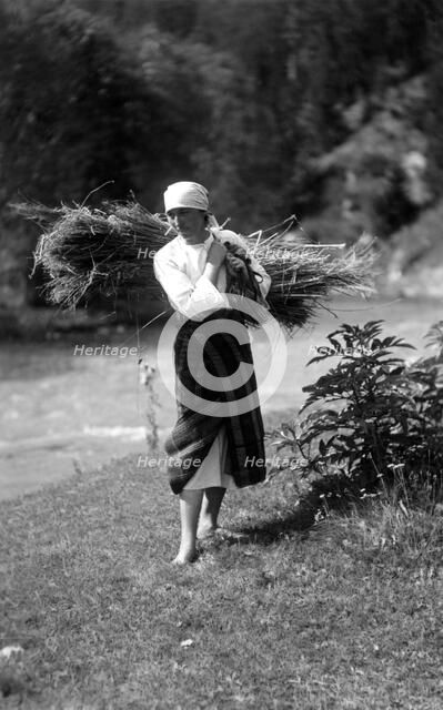 Woman carrying a bundle of sticks, Bistrita Valley, Moldavia, north-east Romania, c1920-c1945. Artist: Adolph Chevalier