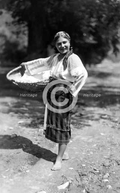 Woman carrying a large basket, Bistrita Valley, Moldavia, north-east Romania, c1920-c1945. Artist: Adolph Chevalier