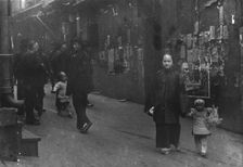 Woman and a child walking down a street, Chinatown, San Francisco, between 1896 and 1906. Creator: Arnold Genthe