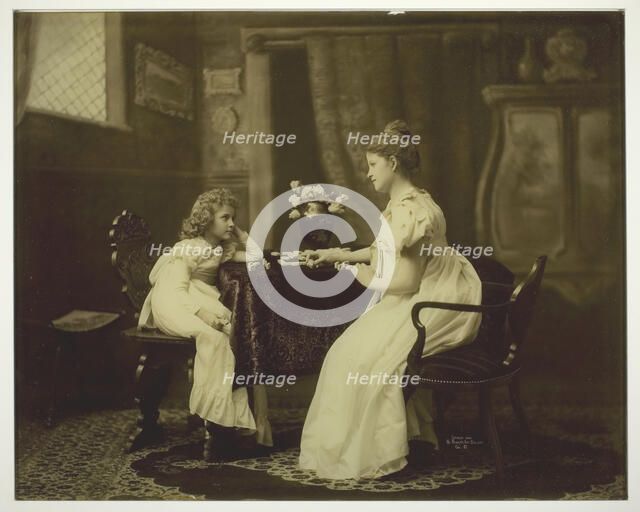 Woman and Child Playing Dominoes at Table, c. 1898. Creator: Unknown.