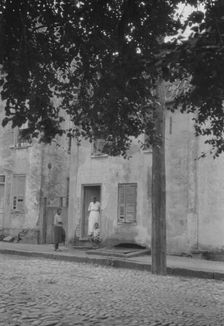 Woman and children standing in or by a doorway, [17 Chalmers Street], Charleston..., c1920-c1926. Creator: Arnold Genthe