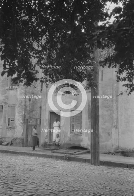Woman and children standing in or by a doorway, [17 Chalmers Street], Charleston..., c1920-c1926. Creator: Arnold Genthe.