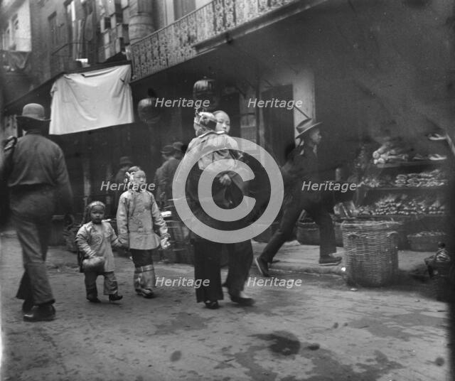 Woman and children walking down a street, Chinatown, San Francisco, between 1896 and 1906. Creator: Arnold Genthe.