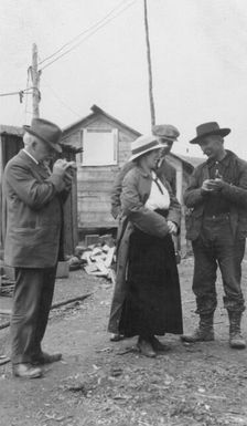Woman and three men talking outside, between c1900 and 1916. Creator: Unknown