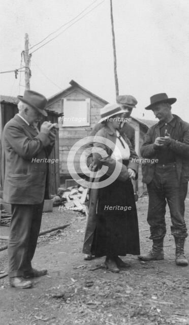 Woman and three men talking outside, between c1900 and 1916. Creator: Unknown.