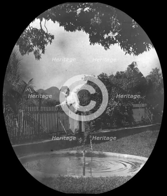 Woman by a pond in a garden, Rio de Janeiro, Brazil, late 19th or early 20th century. Artist: Unknown