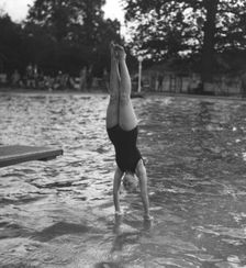 Woman diving into a swimming pool, 20th century