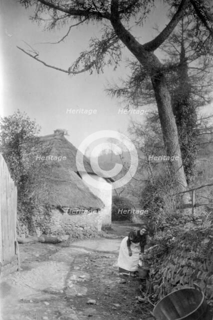 Woman fetching water, Bratton, Minehead, Somerset, c1900. Artist: Farnham Maxwell Lyte