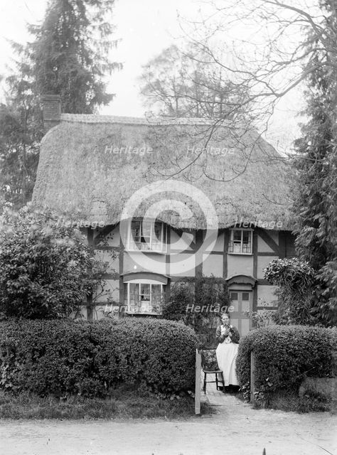 Woman holding her cat at the gate of her cottage, Uffington, Oxfordshire, c1916. Artist: FW Ault