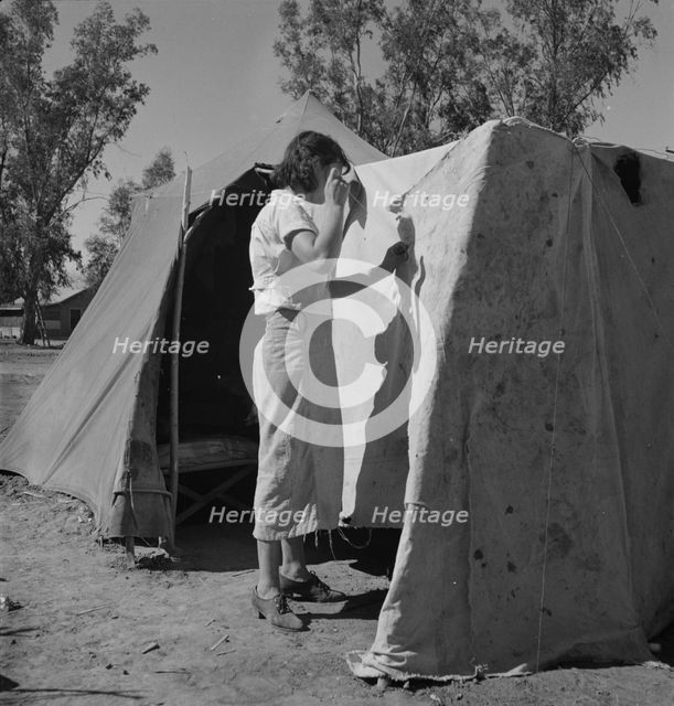 Woman in a California pea pickers' camp, mending the tent, 1937. Creator: Dorothea Lange.
