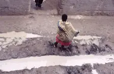 Woman in muddy street, Mopti, Mali, 1990. Creator: Amanda Waite