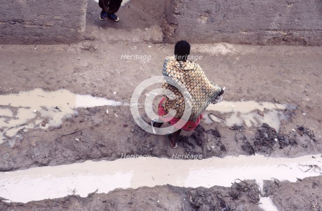 Woman in muddy street, Mopti, Mali, 1990. Creator: Amanda Waite.
