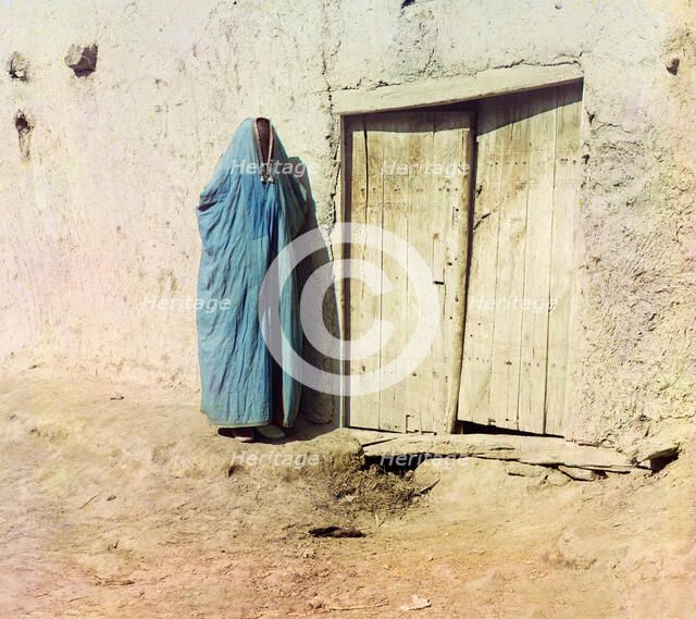 Woman in purdah, standing near wooden door, between 1905 and 1915. Creator: Sergey Mikhaylovich Prokudin-Gorsky.