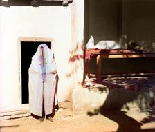 Woman in purdah, standing in front of doowrway, between 1905 and 1915. Creator: Sergey Mikhaylovich Prokudin-Gorsky