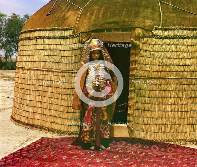 Woman in traditional dress and jewelry standing on rug in front of yurt, between 1905 and 1915. Creator: Sergey Mikhaylovich Prokudin-Gorsky.