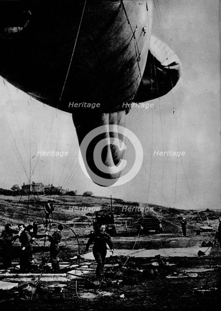 Woman of the WAAF handling a barrage balloon, 1943. Artist: Unknown.