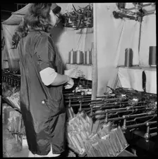 Woman operating a cop winding frame in a textile mill, 1966-1974. Creator: Eileen Deste