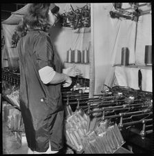 Woman operating a cop winding frame in a textile mill, 1966-1974. Creator: Eileen Deste