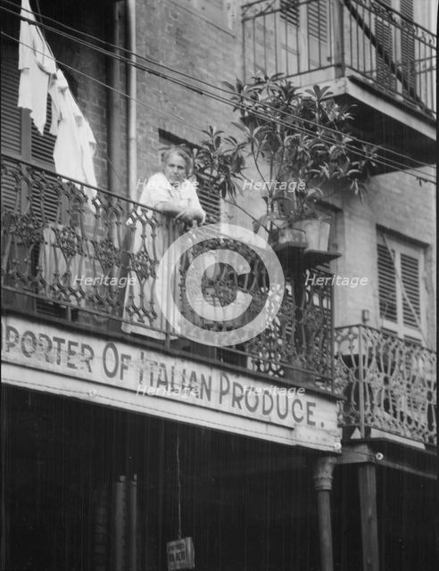 Woman leaning on a balcony, New Orleans, between 1920 and 1926. Creator: Arnold Genthe.