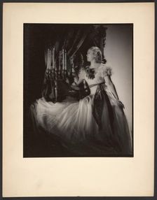 Woman lighting candelabra, 1930s. Creator: Gunther Krampf