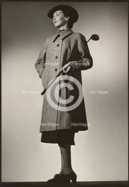 Woman modeling coat with golf club, early 1940s. Creator: Gunther Krampf.