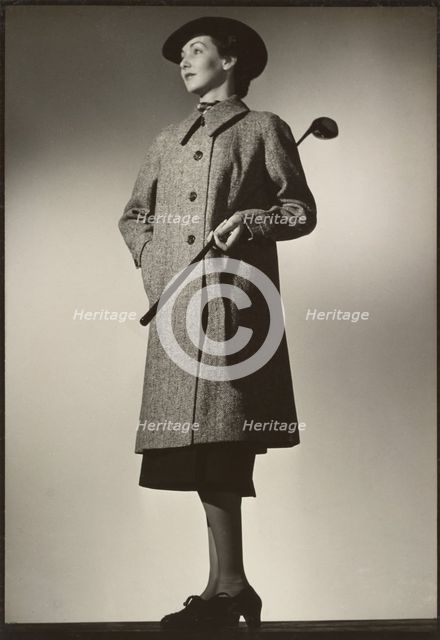 Woman modeling coat with golf club, early 1940s. Creator: Gunther Krampf.