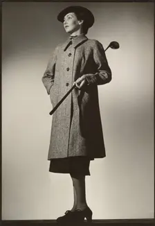 Woman modeling coat with golf club, early 1940s. Creator: Gunther Krampf