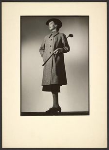 Woman modeling coat with golf club, early 1940s. Creator: Gunther Krampf