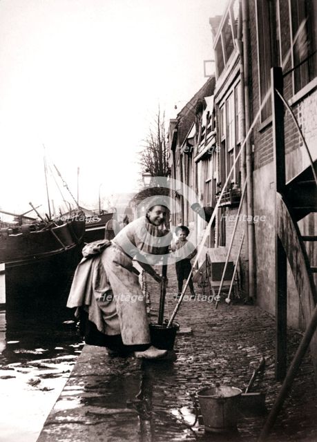 Woman mopping the street, Dordrecht, Netherlands, 1898.Artist: James Batkin