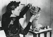 Woman making a hat from wood shavings, German-occupied France, April 1941