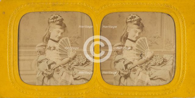 Woman seated on a divan holding a hand fan, 1860s. Creator: E Lamy.