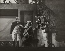 Woman sitting and two men standing, 1938. Creator: Unknown