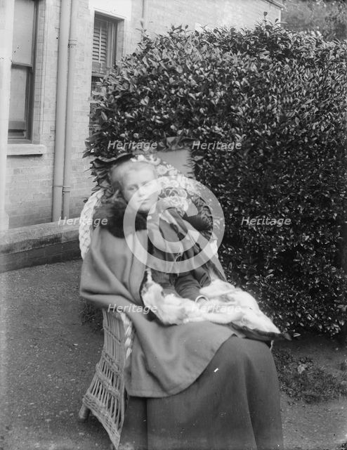 Woman sitting in a chair in a garden, c1900. Creator: Kirk & Sons of Cowes.