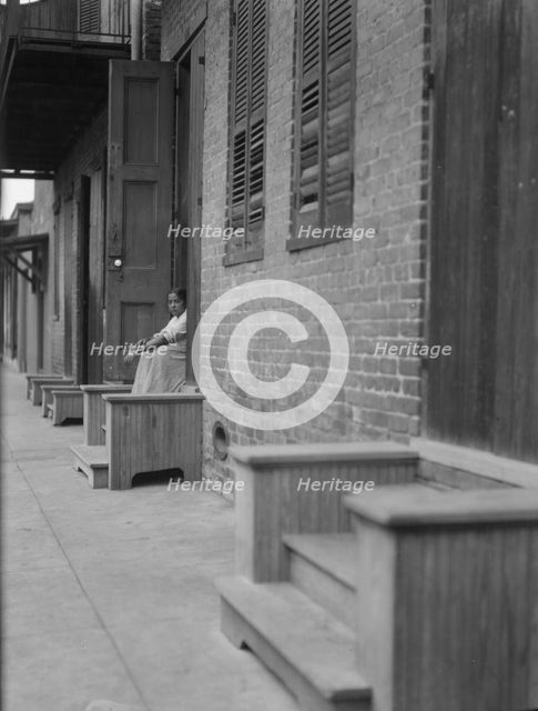Woman sitting on steps, New Orleans or Charleston, South Carolina, between 1920 and 1926. Creator: Arnold Genthe.