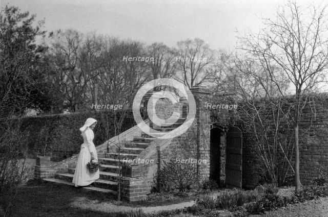 Woman standing at the base of the garden steps, Ufton Court, Ufton Nervet, Berkshire. c1901. Artist: Maxwell-Lyte.