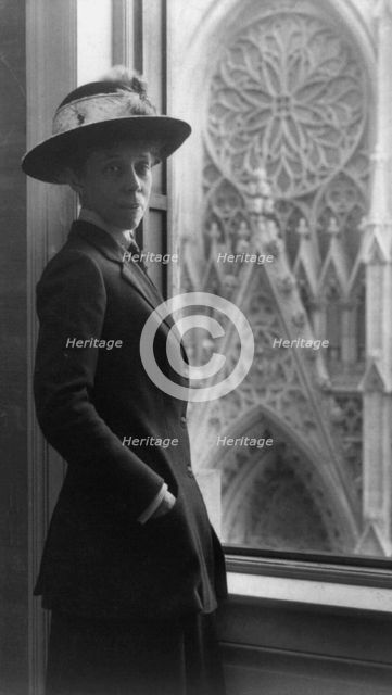 Woman standing by window, 3/4 lgth., facing slightly right, overlooking cathedral door, n.d.. Creator: Frances Benjamin Johnston.