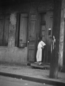 Woman standing in a doorway in the French Quarter, New Orleans, between 1920 and 1926. Creator: Arnold Genthe