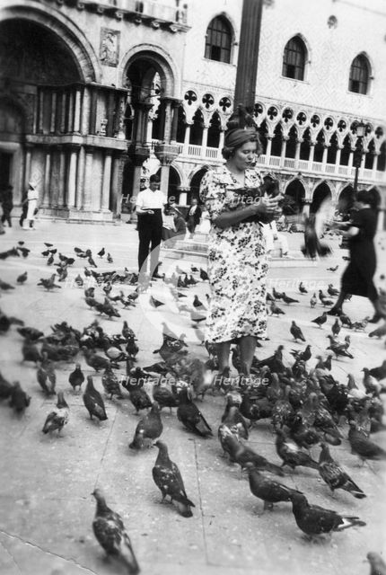 Woman surrounded by pigeons, St Mark's Square, Venice, Italy, 1938. Artist: Unknown