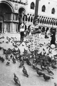 Woman surrounded by pigeons, St Mark's Square, Venice, Italy, 1938