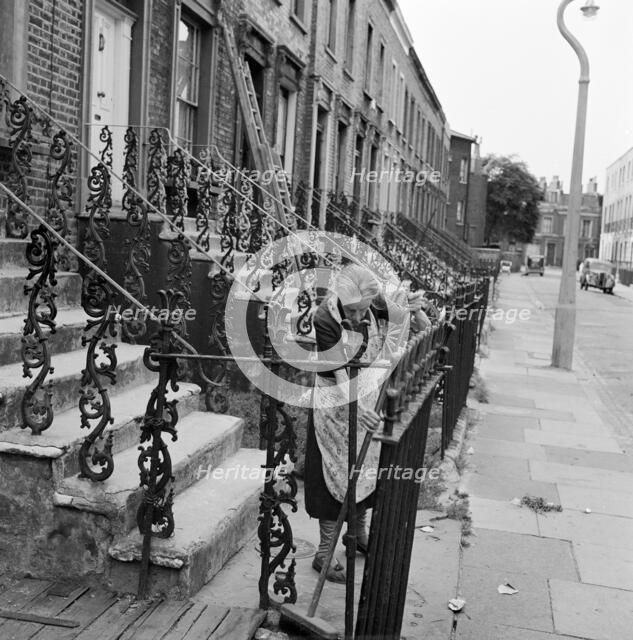 Woman sweeping front steps, London, 1960-1965. Artist: John Gay