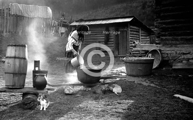 Woman pouring water into a pot, Bistrita Valley, Moldavia, north-east Romania, c1920-c1945. Artist: Adolph Chevalier