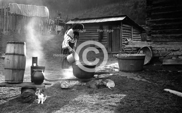 Woman pouring water into a pot, Bistrita Valley, Moldavia, north-east Romania, c1920-c1945. Artist: Adolph Chevalier