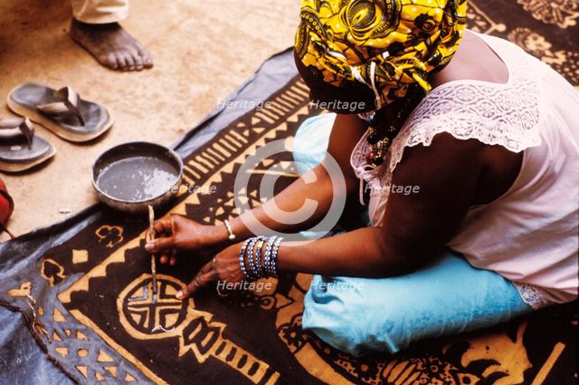Woman painting with mud from the River Niger, Djenné, Mali, 1990. Creator: Amanda Waite.