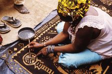 Woman painting with mud from the River Niger, Djenné, Mali, 1990. Creator: Amanda Waite
