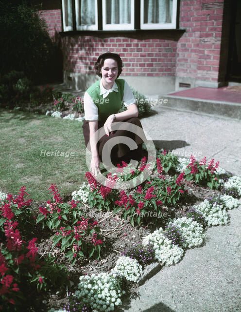 Woman proudly showing off her flower bed, c1955.  Creator: Arthur Charles Kirby Ware.